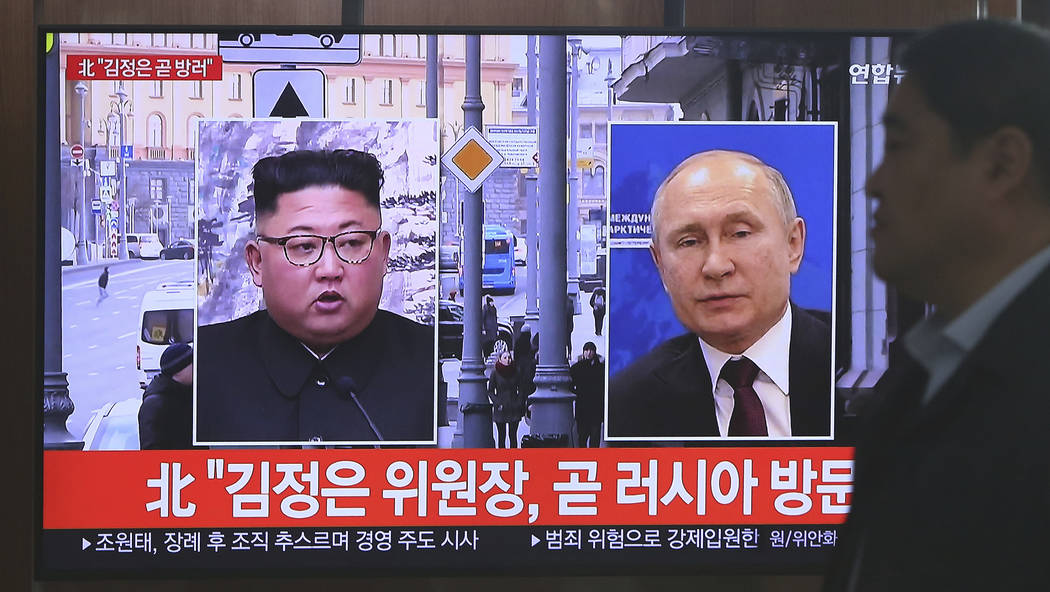 A man passes by a TV screen showing images of North Korean leader Kim Jong Un, left, and Russia ...