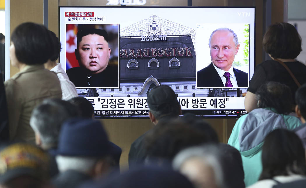 People watch a TV screen showing images of North Korean leader Kim Jong Un, left, and Russian P ...