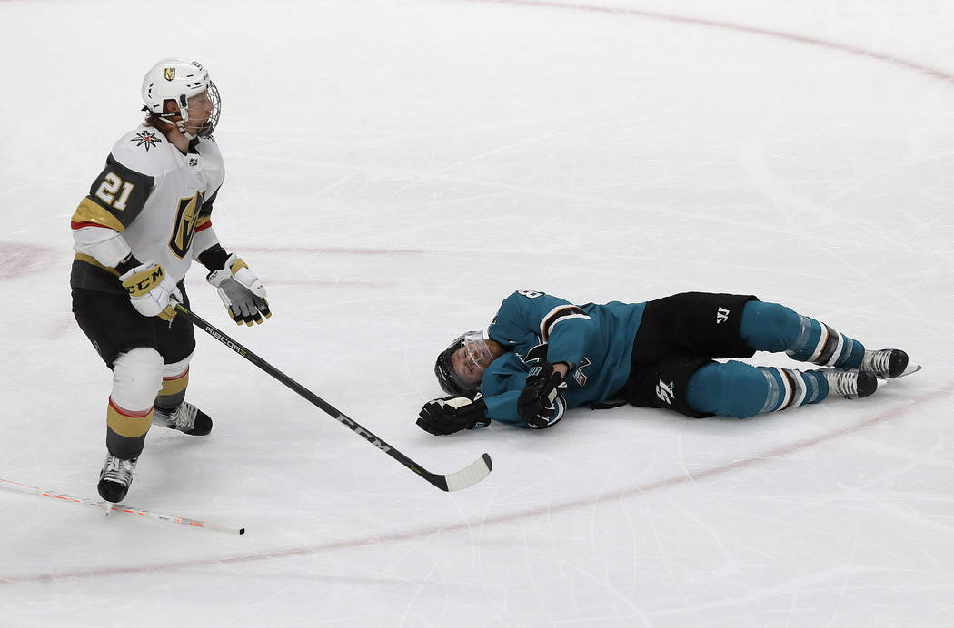 San Jose Sharks center Joe Pavelski, right, lies on the ice next to Vegas Golden Knights center ...