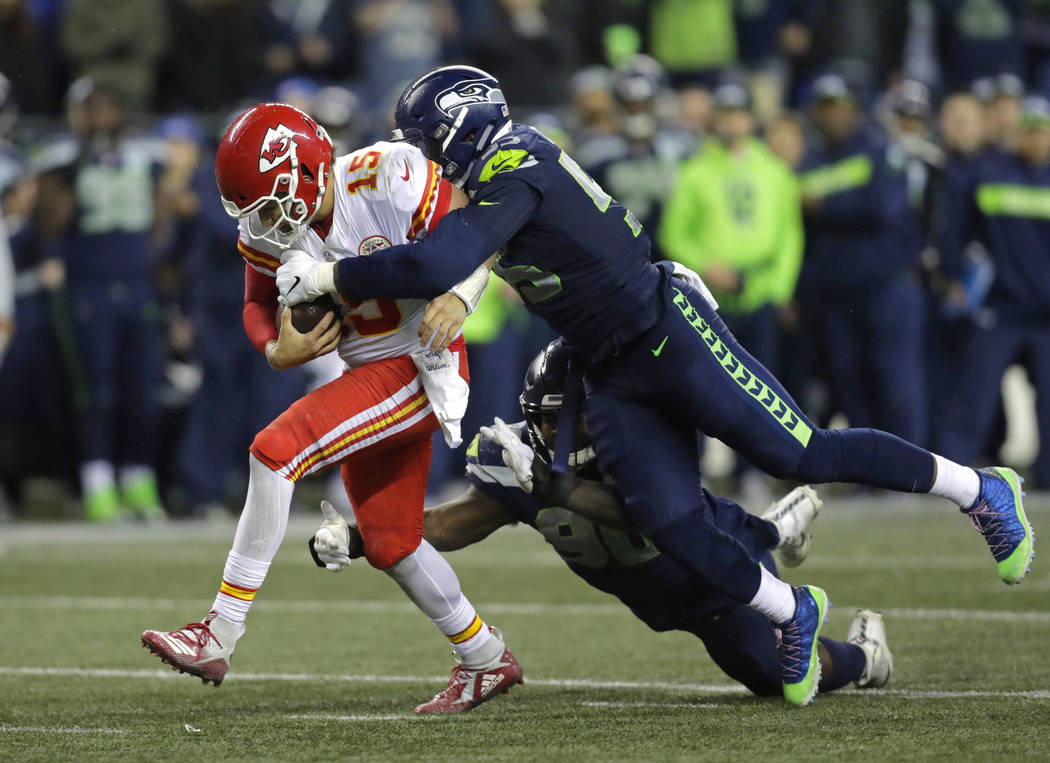 Kansas City Chiefs quarterback Patrick Mahomes (15) is tackled by Seattle Seahawks defensive en ...