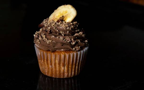 A banana cupcake with chocolate buttercream made by Owner of Cakes, Cookies and Creations Jessi ...