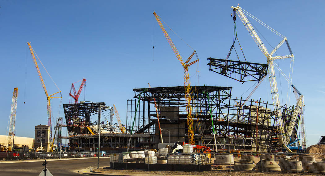 The newest truss is slowly lowered and attached into place atop of Raiders Stadium on Wednesday ...