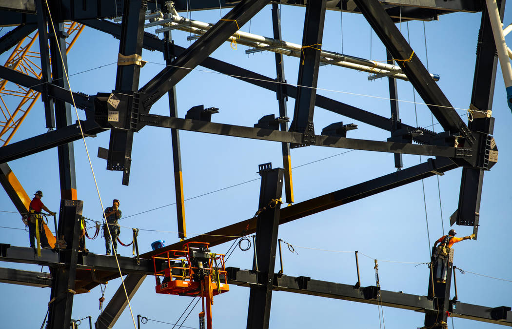 The newest truss is lowered into place and attached by awaiting steelworkers at the top of Raid ...