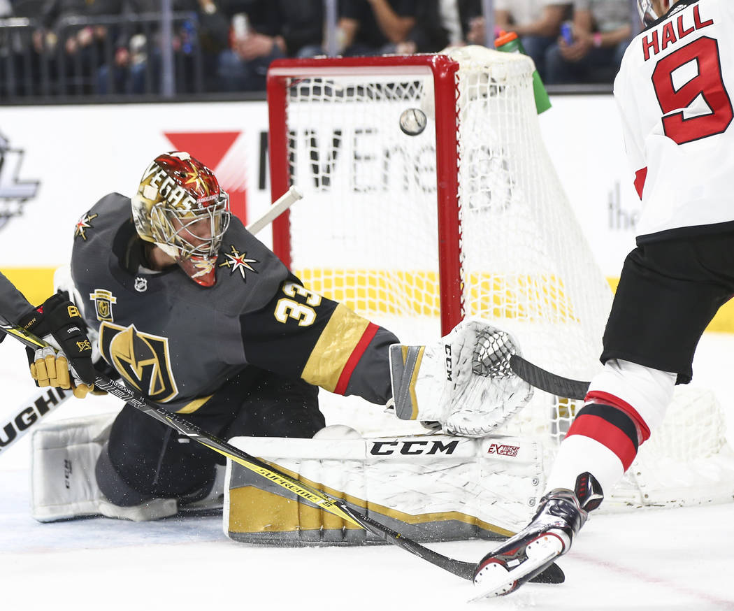 Golden Knights goaltender Maxime Lagace (33) blocks a shot from New Jersey Devils left wing Tay ...