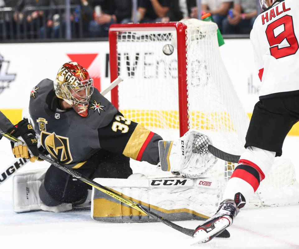 Golden Knights goaltender Maxime Lagace (33) blocks a shot from New Jersey Devils left wing Tay ...