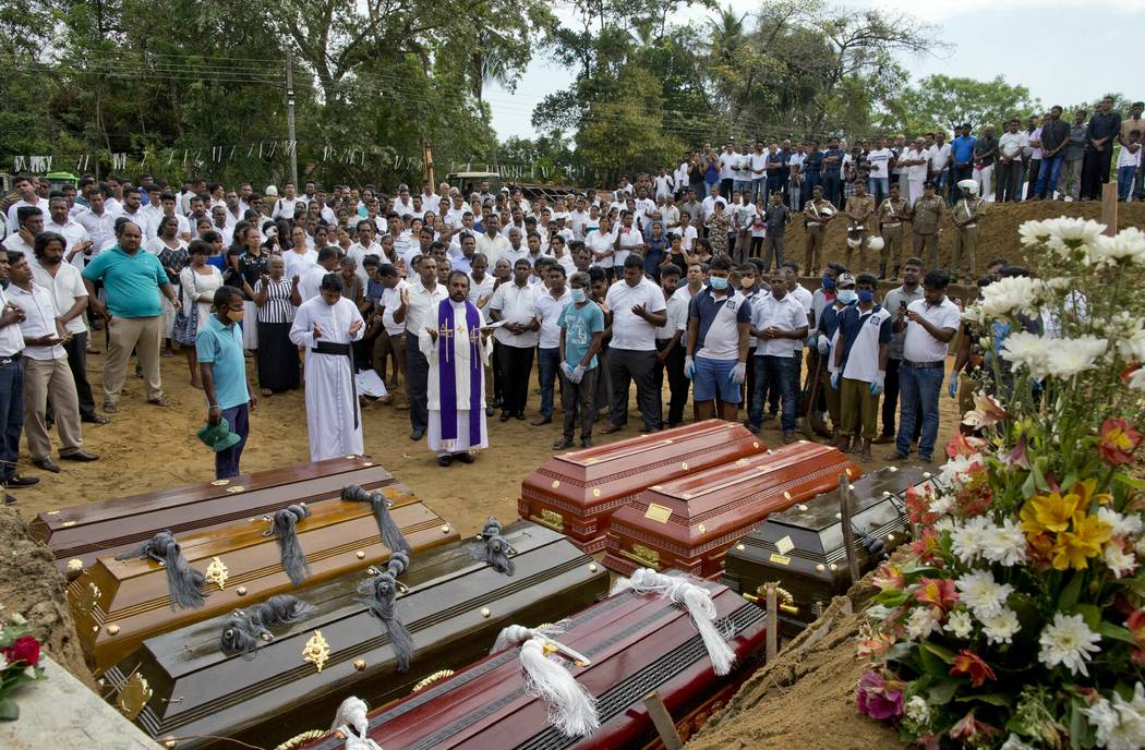 A priest conducts religious rituals during a mass burial for Easter Sunday bomb blast victims i ...