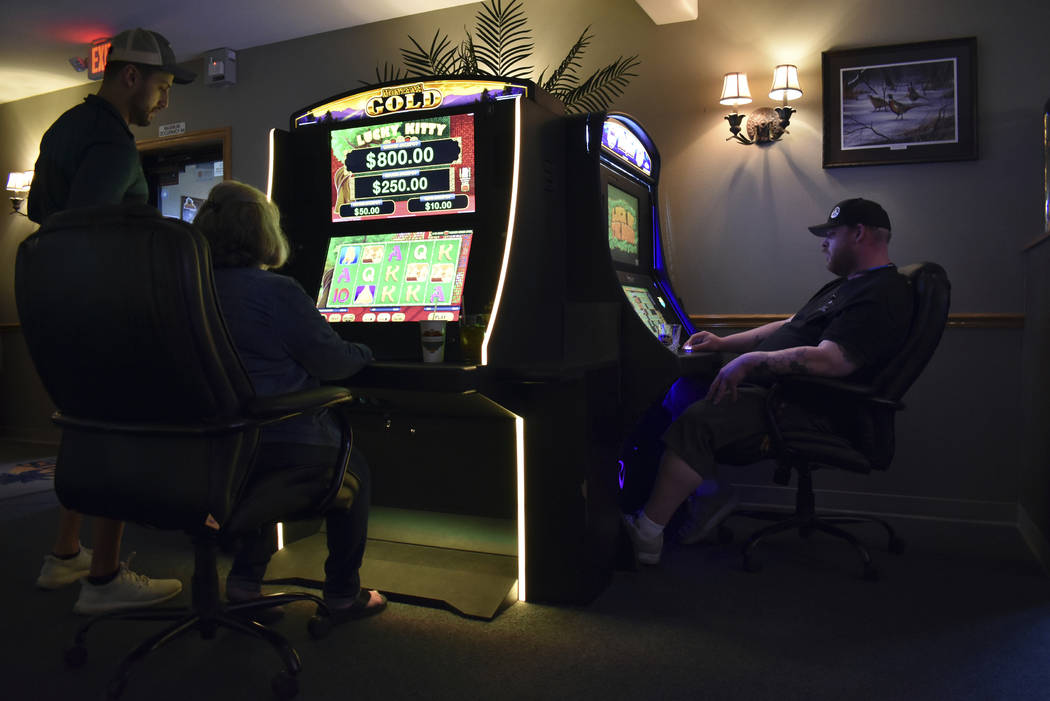 Patrons are seen playing video poker machines at the Palm Grand Casino in Billings, Mont., Tues ...