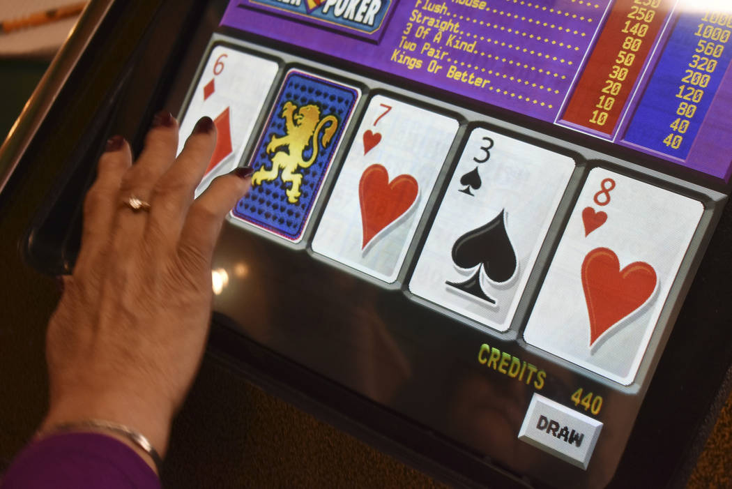 A player swipes the screen on a video poker machine at the Monte Bar and Casino in Billings, Mo ...