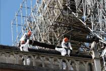 Workers install protections on Notre Dame cathedral Wednesday, April 24, 2019 in Paris. Profess ...