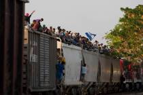 Central American migrants ride atop a freight train during their journey toward the U.S.-Mexico ...