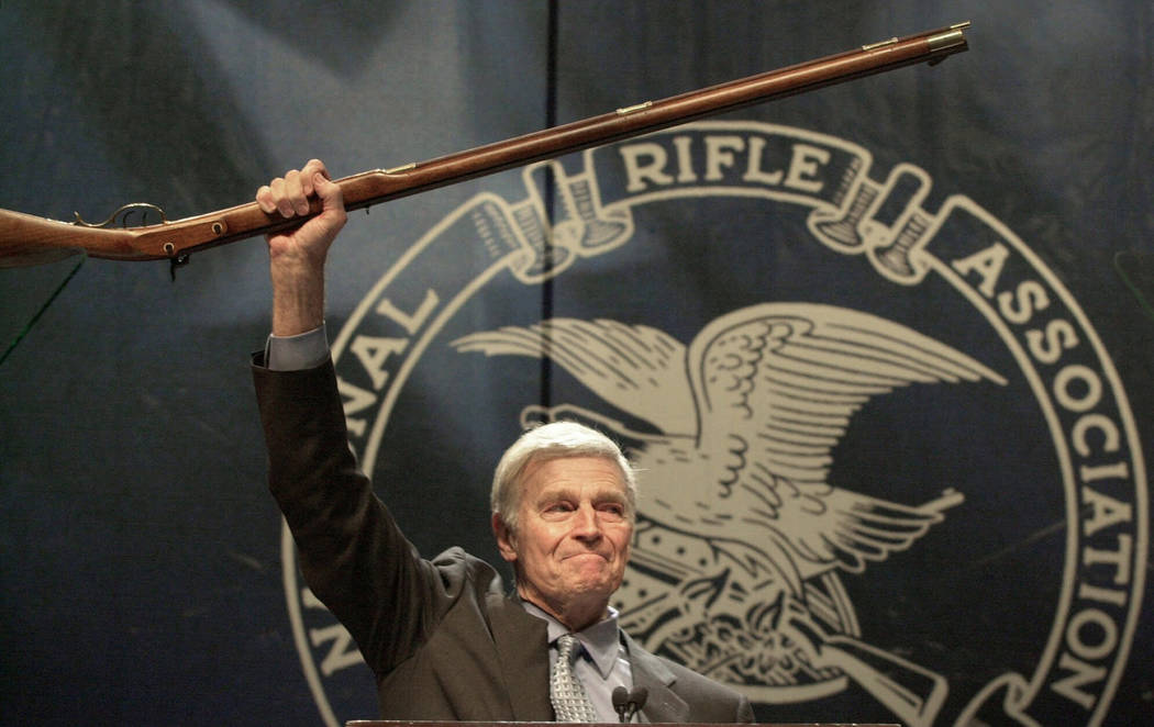 FILE - In this May 20, 2000, file photo, NRA president Charlton Heston holds up a musket as he ...