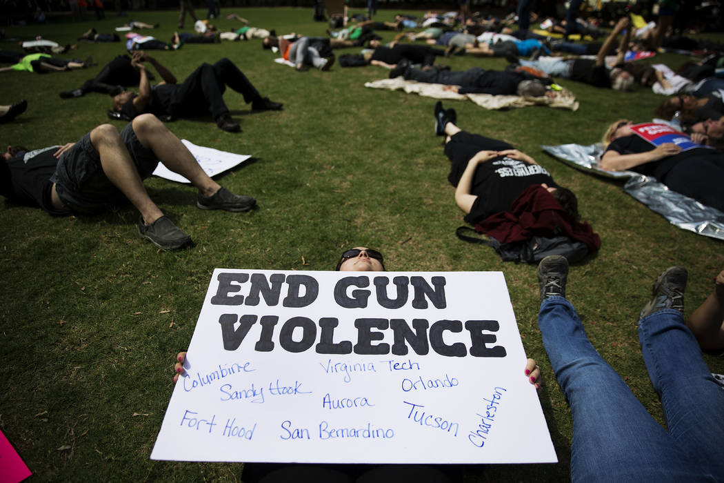 Demonstrators hold hands during a "die-in" protest April 28, 2017, against the National Rifle A ...