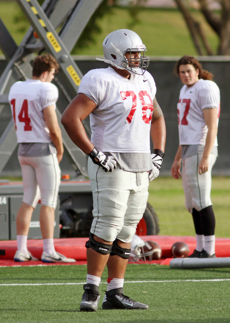 UNLV's Justin Polu, center, sits out on a drill rotation and watches teammates at UNLV football ...