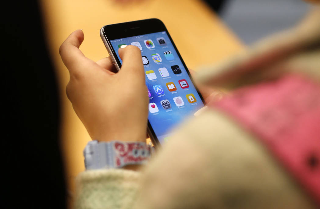 A child holds an Apple iPhone 6S on Sept. 25, 2015, at an Apple store on Chicago's Magnificent ...