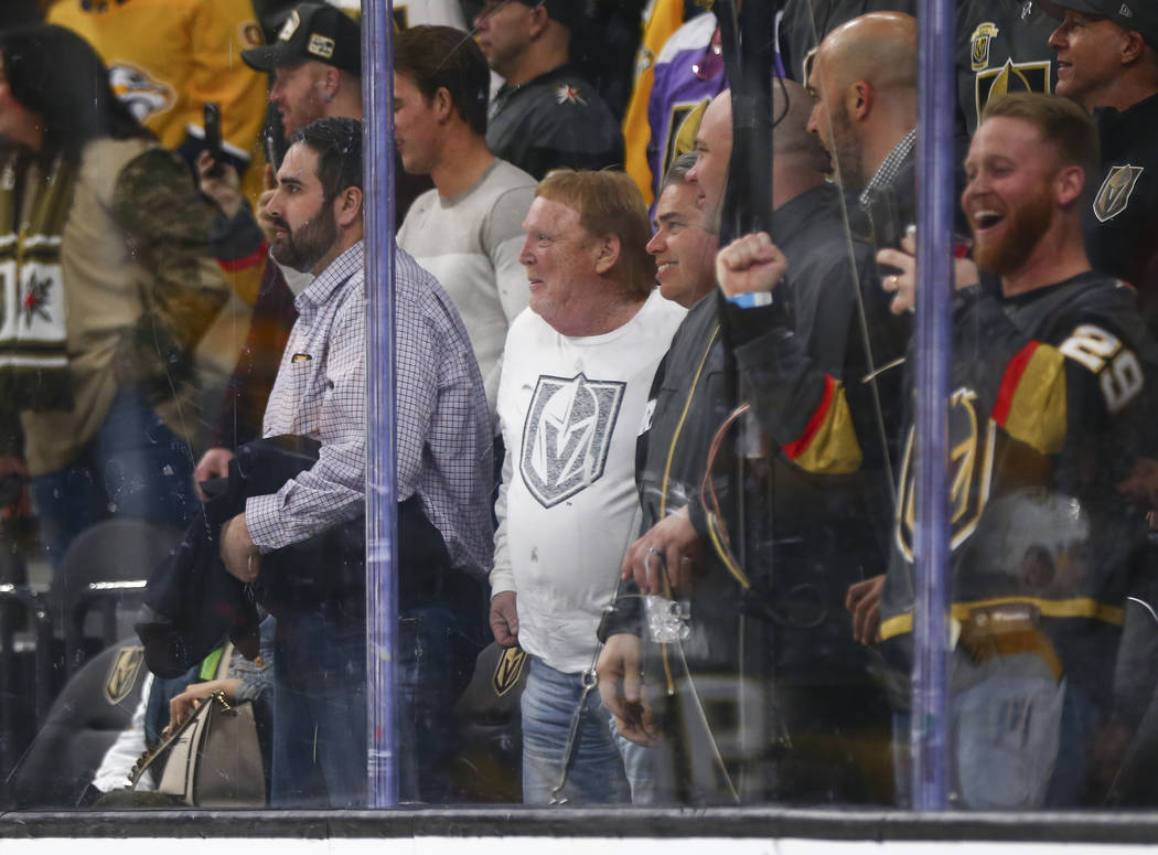 Oakland Raiders owner Mark Davis, center in white, attends an NHL hockey game between the Golde ...
