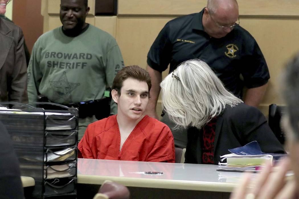 Parkland school shooting suspect Nikolas Cruz speaks with his attorney in court for a defense m ...