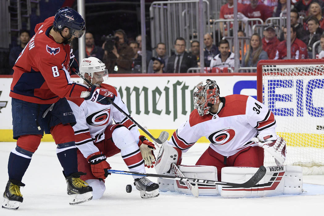 Washington Capitals left wing Alex Ovechkin (8), of Russia, battles for the puck against Caroli ...