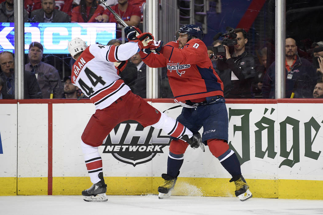 Washington Capitals left wing Alex Ovechkin (8), of Russia, shoves Carolina Hurricanes defensem ...