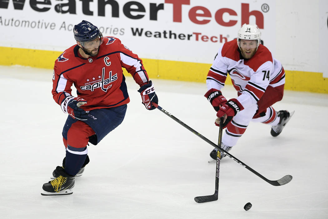 Washington Capitals left wing Alex Ovechkin (8), of Russia, battles for the puck against Caroli ...