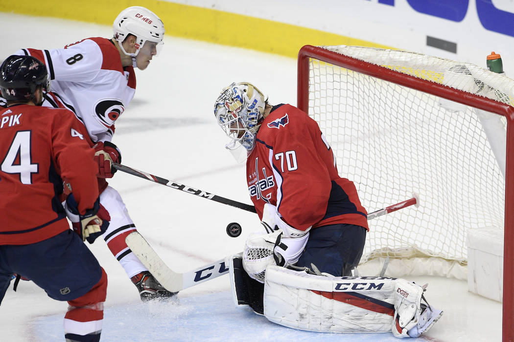 Carolina Hurricanes right wing Saku Maenalanen (8), of Finland, battles for the puck against Wa ...