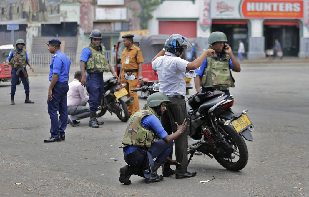 Sri Lankan navy soldiers perform security checks on motorists at a road in Colombo, Sri Lanka, ...