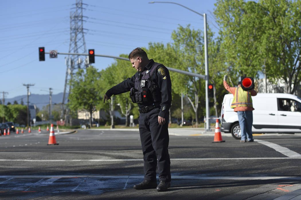 Police and road crews work the scene after a car crash at the intersection of El Camino Real an ...