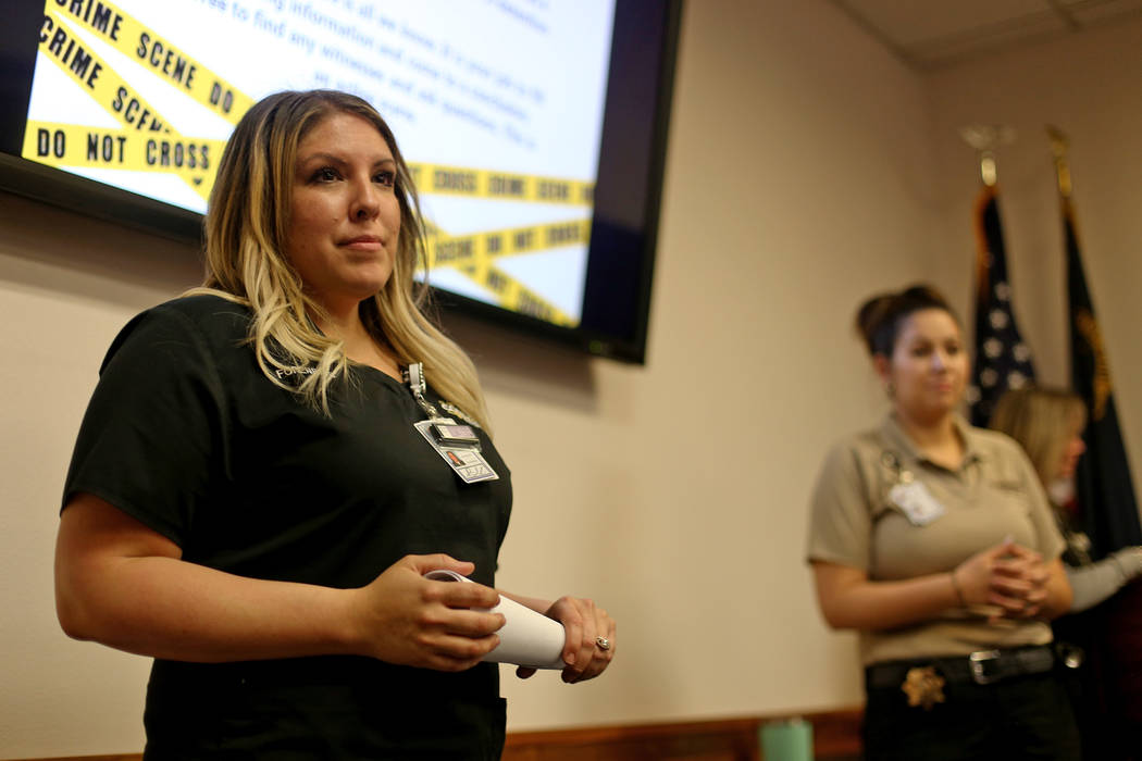 Bri Kinard, from the senior forensic team, talks to kids at the at the coroner office's Take Ou ...