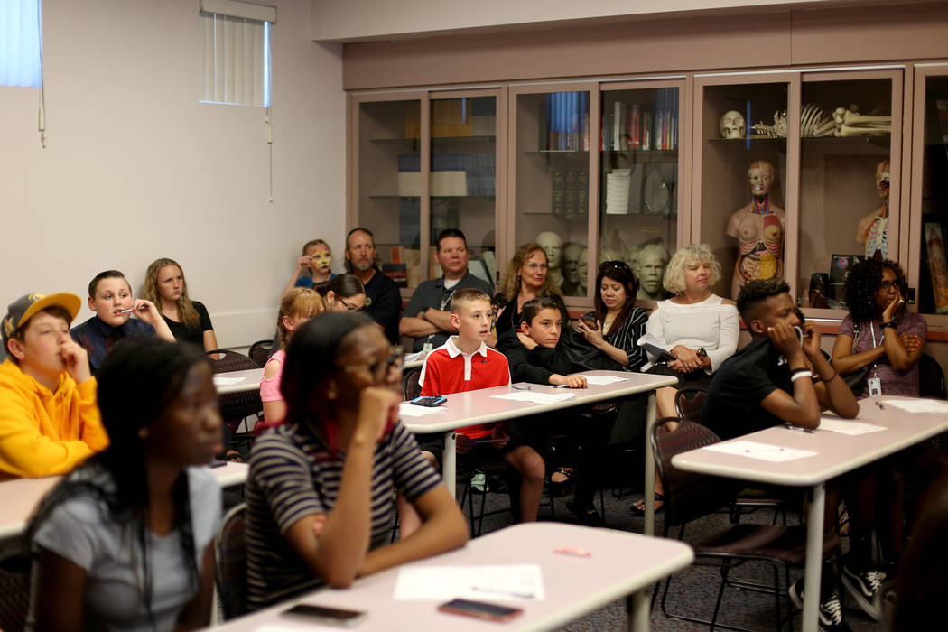 Kids listen to professionals at the at the coroner office's Take Our Daughters and Sons to Work ...