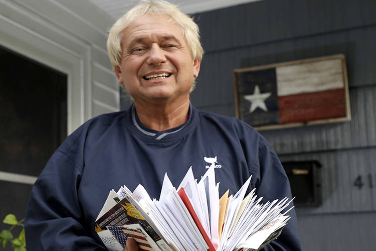 Rex Teter, a member of the Electoral College, holds two days of delivered mail at his home in P ...