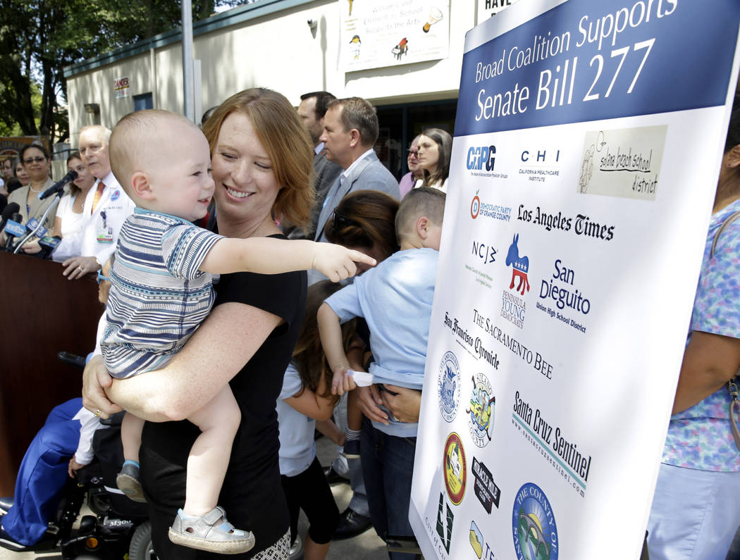 FILE - In this June 30, 2015, file photo, Jennifer Wonnacott holds her son, Gavin, as he points ...