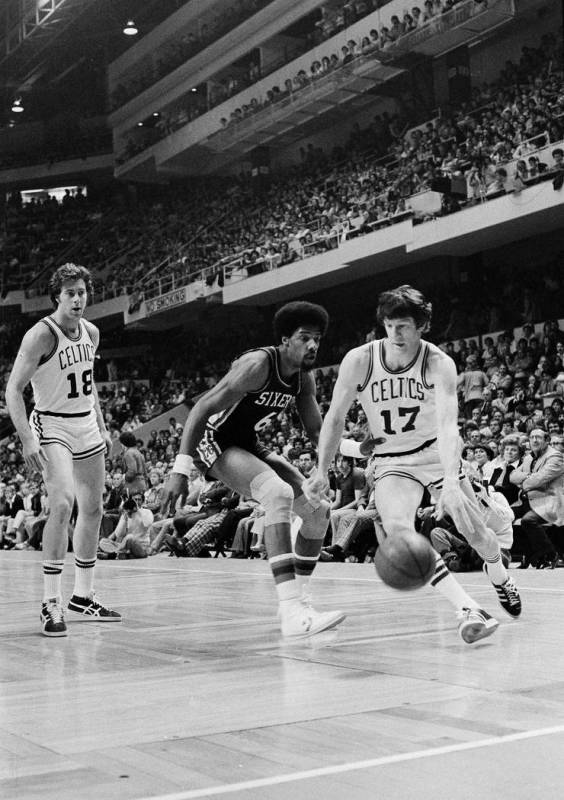 Philadelphia's Julius Erving gives Boston's John Havlicek a nudge in the waist as he dribbles p ...