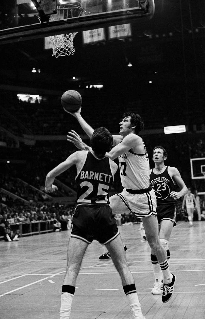 John Havlicek (17) of the Boston Celtics lays up a shot over the defense of Jim Barnett (25) of ...