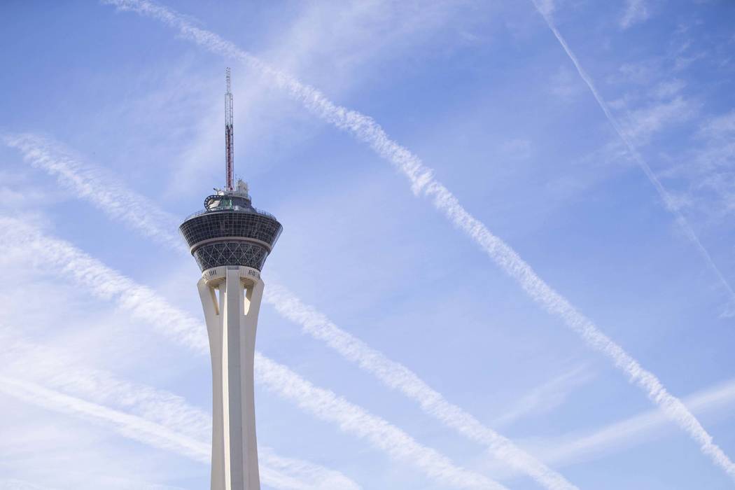 Vapor trails left behind by airplanes are seen above the Stratosphere tower in Las Vegas, Satur ...