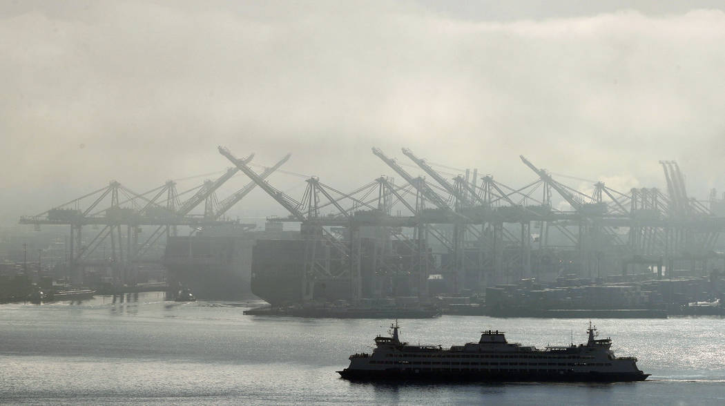 FILE - In this Dec. 31, 2018, photo a Washington state ferry sails on a foggy day near cranes a ...