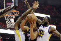 Houston Rockets guard Eric Gordon (10) is stopped by Golden State Warriors defenders Jordan Bel ...