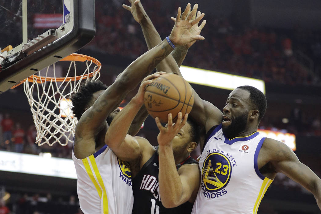 Houston Rockets guard Eric Gordon (10) is stopped by Golden State Warriors defenders Jordan Bel ...