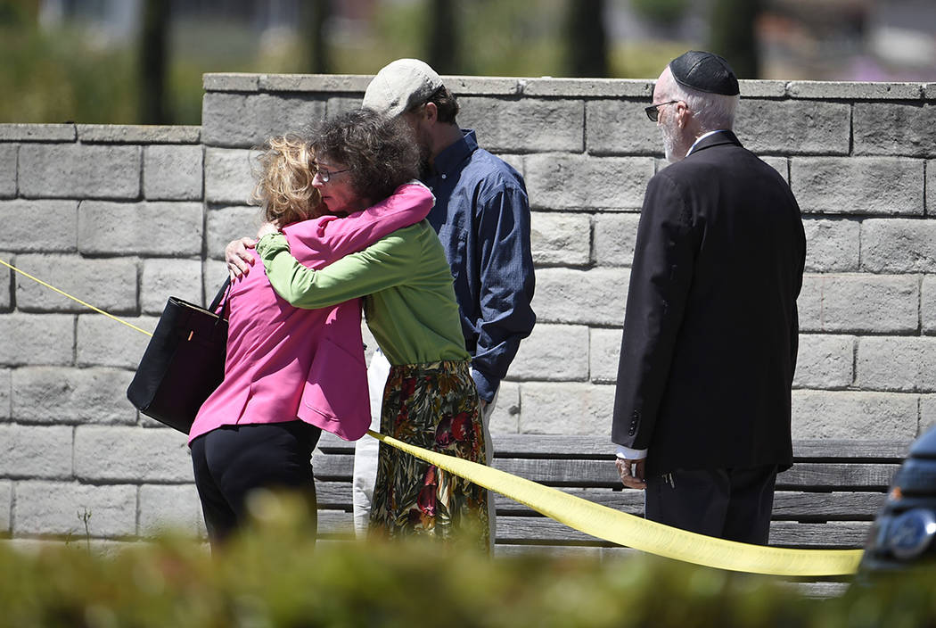 Synagogue members console one another outside of the Chabad of Poway Synagogue Saturday, April ...