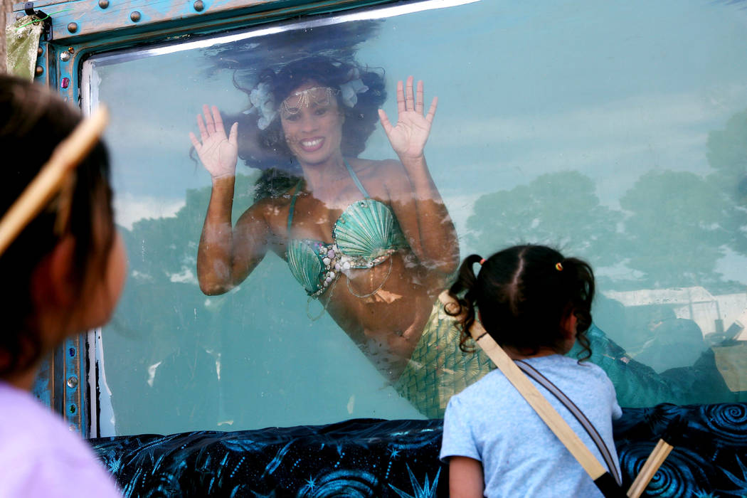 Mermaid Farasha says hi to twins Hanna Sparks, 4, left, and Trinity Sparks, 4, at the Pirate Fe ...