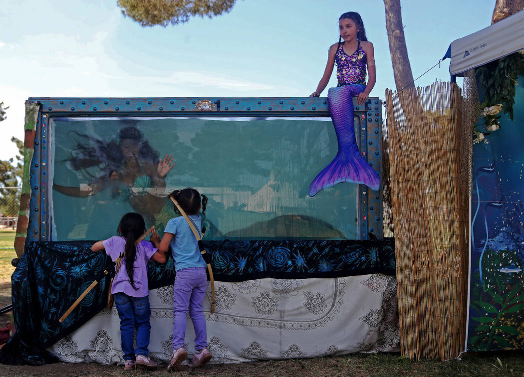 Mermaid Farasha says hi to twins Hanna Sparks, 4, left, and Trinity Sparks, 4, next to Mermaid ...