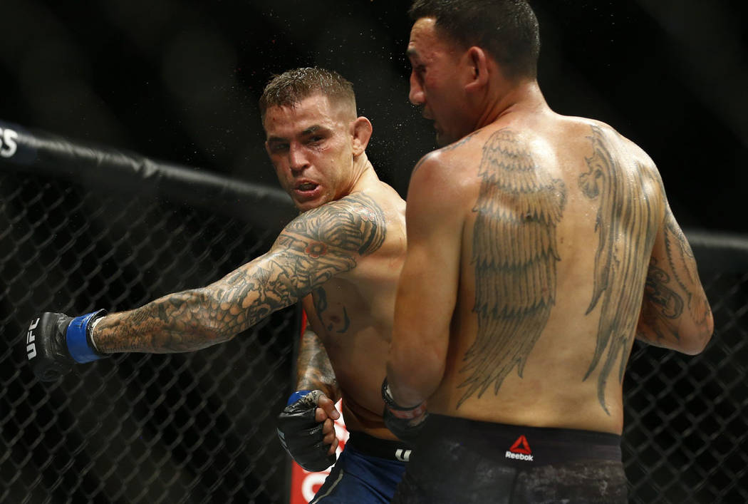 Dustin Poirier, left, fights Max Holloway during an interim lightweight title mixed martial art ...