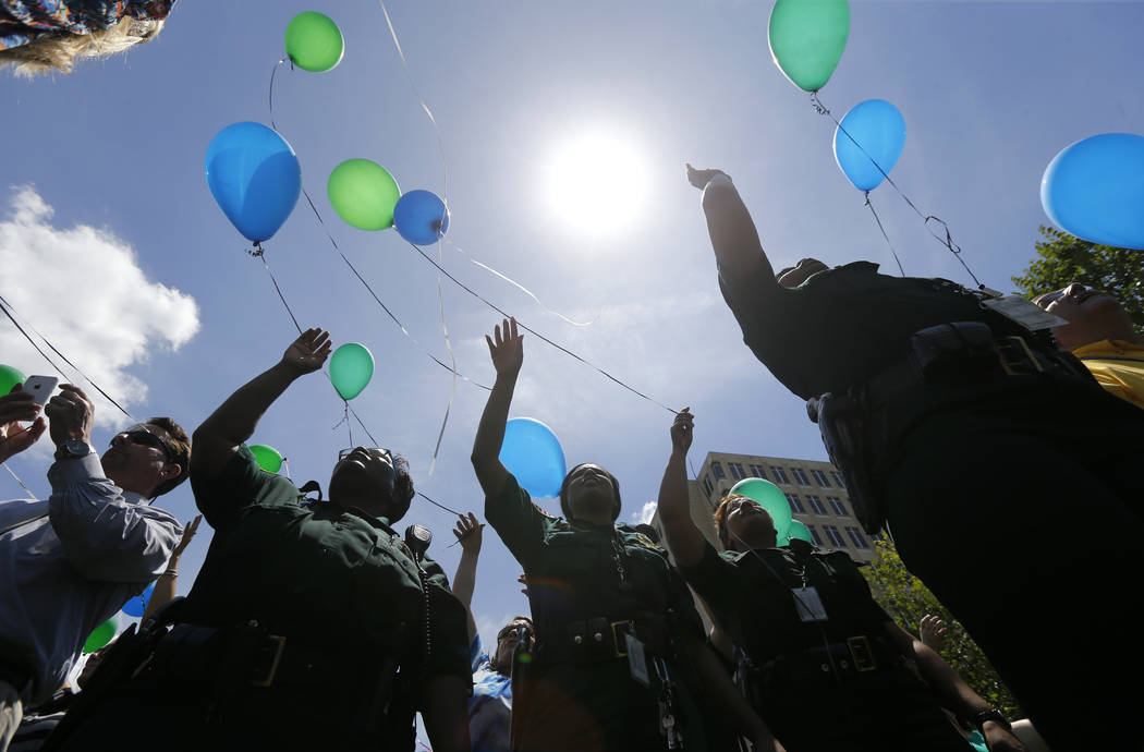 FILE - In this July 20, 2106 file photo, East Baton Rouge Sheriff's deputies release balloons a ...