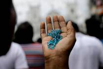 A Sri Lankan Catholic holds her rosary as she prays on a road during a brief holly mass held ou ...