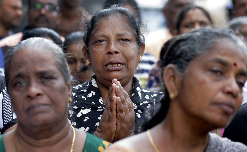 Sri Lankan Catholics pray on a road during a brief holly Mass held outside the exploded St. Ant ...