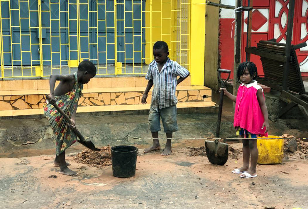 Children clear away mud due to flooding in Pemba, Mozambique, Sunday, April 28, 2019. Serious f ...