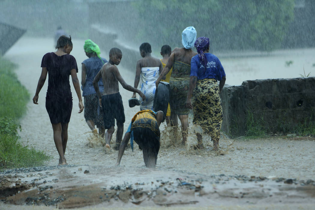 People leave their flooded homes, in Natite neighbourhood, in Pemba, on the northeastern coast ...