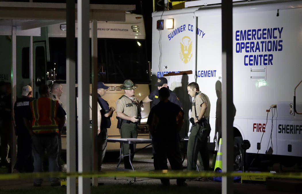 Law enforcement officials work at a command center set up at North Sumner Elementary School Sat ...