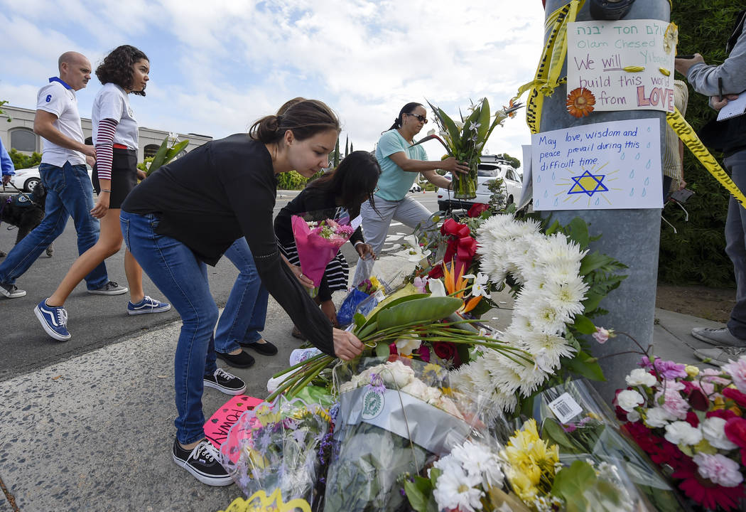 A group of Poway residents bring flowers and cards to a memorial outside of the Chabad of Poway ...