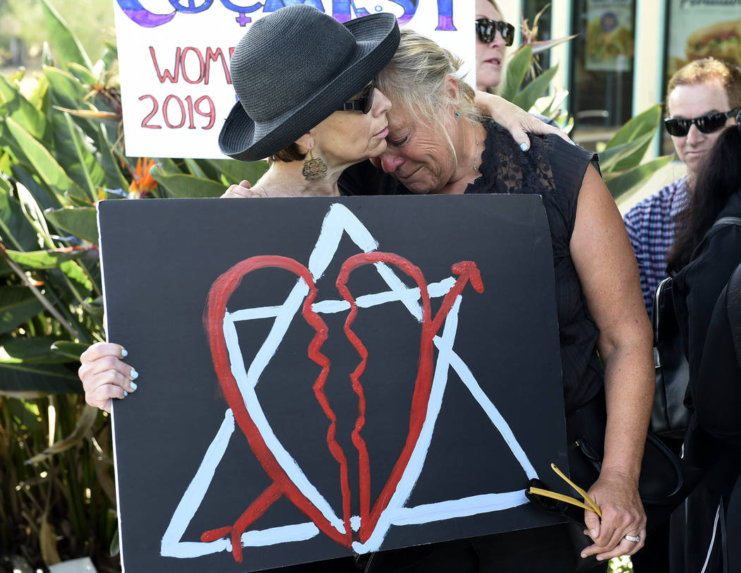 Leslie Gollub, left, and Gretchen Gordon hug at a vigil held to support the victims of Saturday ...