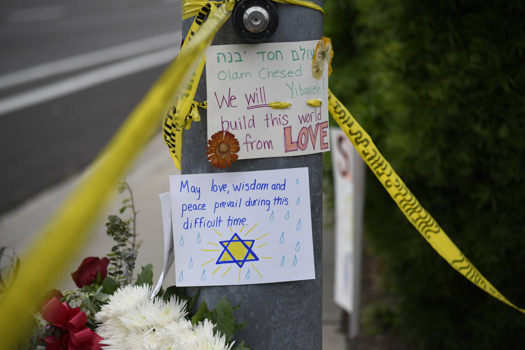 Flowers and signs sit at a memorial across the street from the Chabad of Poway synagogue, Sunda ...