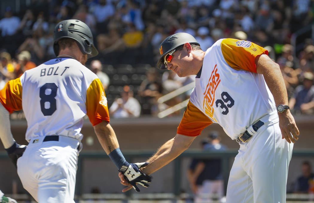 Base runner Skye Bolt (8) is congratulated on a score by Aviators manager Fran Riordan (39) as ...